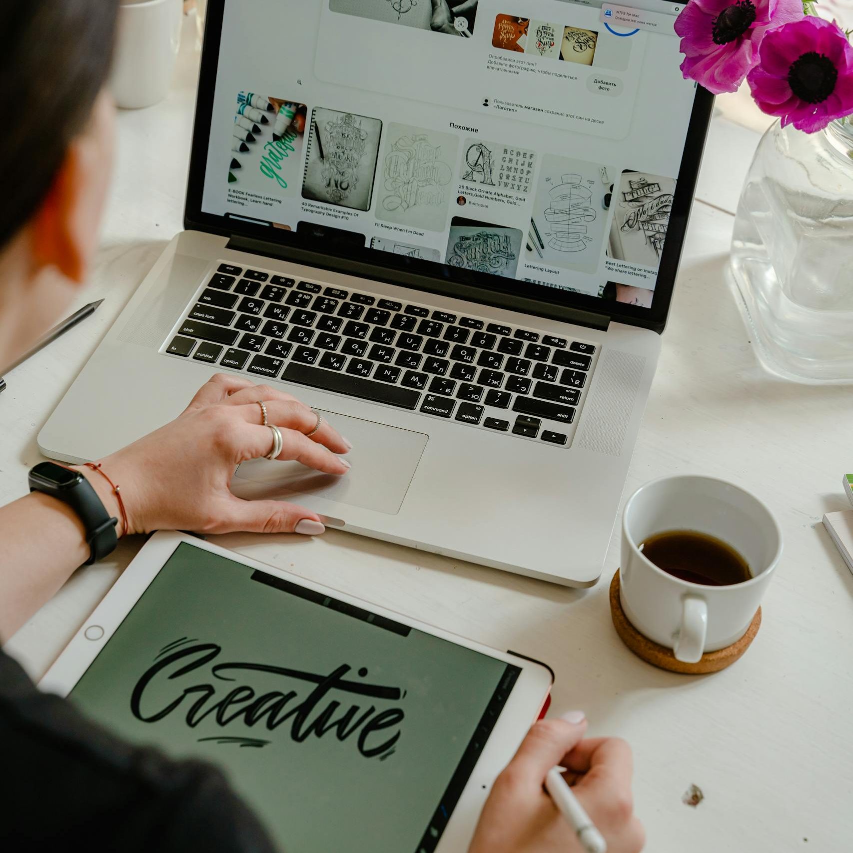 Creative work session featuring a woman using a tablet and laptop for design projects.
